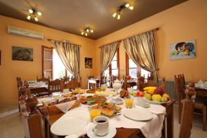 a dining room with a table with food on it at Hotel Marialena in Ancient Epidauros