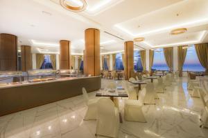 a restaurant with white chairs and tables and a bar at Vivaldi Hotel in St. Julianʼs