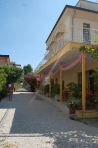 a woman walking down a street next to a building at Hotel Perugini in Rimini