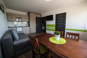 a living room and kitchen with a table and a couch at Flaming - domki letniskowe in Rowy