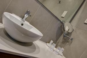 a bathroom with a sink and a toilet at Golden Tulip Vivaldi Hotel in St. Julianʼs