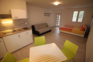 a kitchen and a living room with a bed and a table at Apartments Marinko in Stari Grad