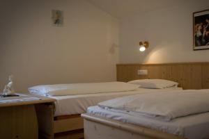 Una habitación con 2 camas y una mesa con en Berggasthof Stern, en Predoi