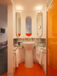 a bathroom with a sink and two mirrors at My Brighton in Brighton & Hove