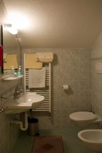 y baño con lavabo y aseo. en Berggasthof Stern, en Predoi
