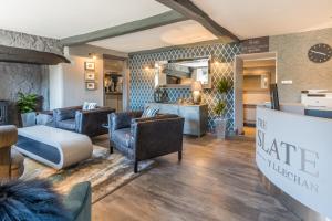 a hotel lobby with couches and a table and chairs at The Slate in Bangor