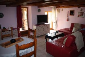 a living room with a couch and a tv at Normandy Nature Paradise in Vire