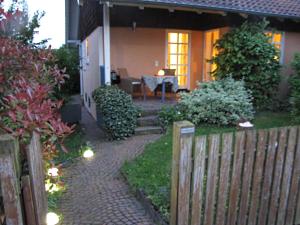 a house with a fence and a brick walkway at Ferienwohnung Am Odenwaldlimes in Vielbrunn