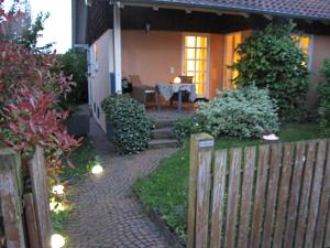 ein Haus mit einem Zaun und einem Ziegelweg in der Unterkunft Ferienwohnung Am Odenwaldlimes in Vielbrunn