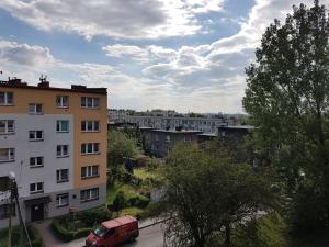 una furgoneta roja estacionada frente a un edificio en MSC Apartments Chorzow Centrum, en Chorzów