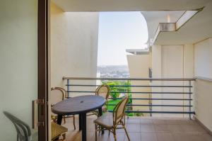 balcón con mesa, sillas y ventana en Apartament Encosta Da Orada, en Albufeira