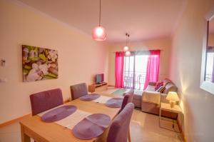 - un salon avec une table, des chaises et un canapé dans l'établissement Apartament Encosta Da Orada, à Albufeira