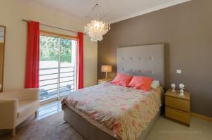 - une chambre avec un lit et une grande fenêtre dans l'établissement Apartament Encosta Da Orada, à Albufeira