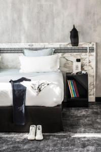 فندق لي بان باريس في باريس: غرفة نوم بسرير كبير مع زوجين من الاحذية