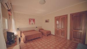 una camera d'albergo con due letti e una televisione di Cassiodoro Rooms Affittacamere a Catanzaro