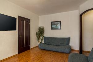 uma sala de estar com um sofá e uma cadeira em Lux 3-bedroom Most City area em Dnipro