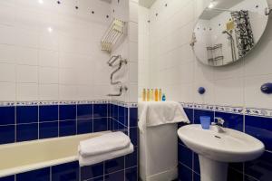 uma casa de banho azul e branca com um lavatório e uma banheira em Lux 3-bedroom Most City area em Dnipro