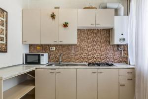 uma cozinha com armários brancos, um lavatório e um micro-ondas em Lux 3-bedroom Most City area em Dnipro