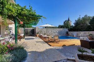 a patio with chairs and an umbrella next to a pool at Villa Lavanda in Podgora