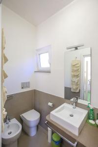 ポルト・サント・ステーファノにあるSunny Peace Apartmentのバスルーム(洗面台、トイレ、鏡付)