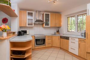 cocina con armarios de madera y horno con fogones en Haus Elisengrund, en Seefeld in Tirol