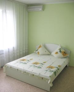 a bedroom with a bed with pillows and a window at Guest House 1279 in Zatoka