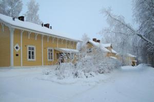 Una casa amarilla con nieve al costado. en Gran Hotellihuoneistot 1, en Suolahti