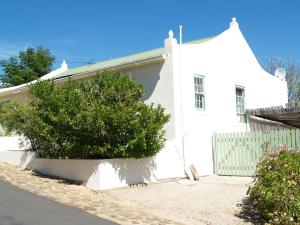 una casa bianca con un cespuglio davanti di Room @ Irissa Sanctuary a De Rust