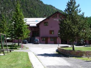 a pink building with cars parked in front of it at Hotel Clari in Claviere