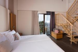 a hotel room with a bed and a staircase at Elite City Resort in Kalamata