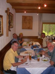 un grupo de personas sentadas en una mesa en un restaurante en Berggasthof Stern, en Predoi