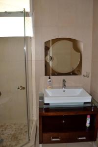 un baño con lavabo y espejo en 104 Ipanema Beach, en Durban 17 fotos más