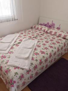 a bed with white towels and pink flowers on it at Lavanda Haus in Vodnjan