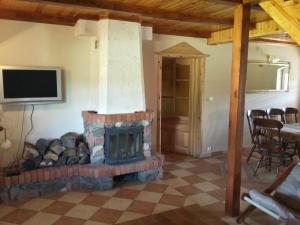 a living room with a brick fireplace and a tv at Domek Gościnny Natania in Jedwabno