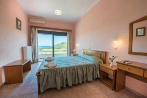 a bedroom with a bed with a view of the ocean at Blue Bay Hotel in Charamida