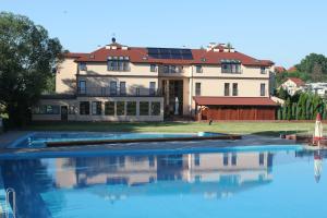 a large house with a swimming pool in front of it at Hotel Oaza in Prudnik