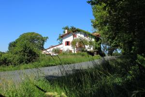 uma casa no topo de uma colina com uma estrada em La Ferme Ostalapia em Ahetze