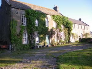 an ivycovered building with a pathway in front of it at Hamsteels Hall Cottages in Langley Park