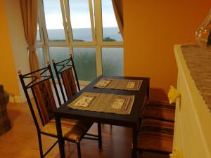a dining room table with two chairs and a window at Apartamento Talako in Bermeo