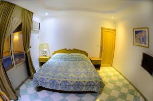 吉達的住宿－阿爾穆爾簡海灘度假村，一间卧室设有床和两张桌子,还有一扇门
