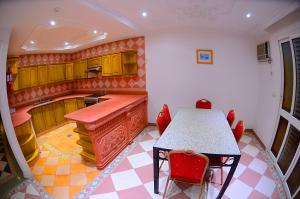 منتجع المرجان بيتش في جدة: مطبخ مع طاولة وبعض الكراسي الحمراء