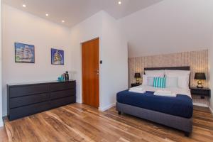 a bedroom with a large bed and a wooden floor at MiraMar - Parking, wi-fi, Kuchnia ogólnodostępna in Krynica Morska