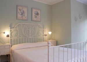 una camera con un letto bianco e due quadri appesi al muro di Ca' Borgo delle Rane a Pernumia
