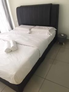 ein großes Bett mit weißer Bettwäsche und zwei Kissen in der Unterkunft Hyve Cyber Bistari in Cyberjaya