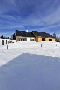 einen schneebedeckten Hof mit einem Haus im Hintergrund in der Unterkunft Apartmány no.823 in Bublava