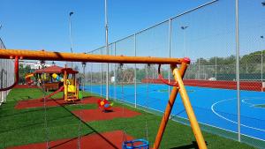 a batting cage with a playground with a basketball court at Elite City Resort in Kalamata