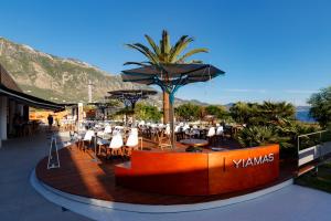 a restaurant with tables and chairs and umbrellas at Elite City Resort in Kalamata