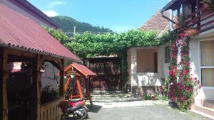 a scooter parked in front of a building with flowers at Pensiunea Răzvan in Gura Râului