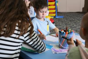 a group of children sitting at a table coloring at Elite City Resort in Kalamata