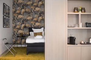 
a bedroom with a bed and a chair at Hotel 't Keershuys in Den Bosch
